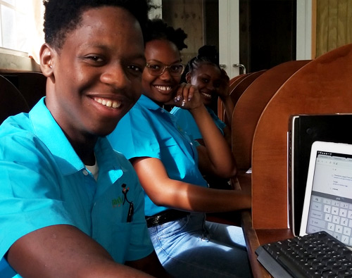 College students sitting in computer lab. 1 male, 2 female