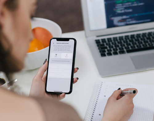 Woman looking at phone, copying information.